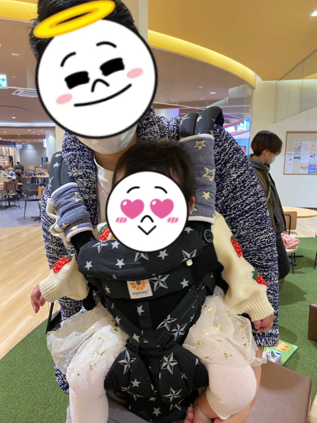 エルゴで抱っこ中の様子（パパと赤ちゃんの顔はスタンプで隠しています）